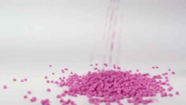 Plastic pellets spilling on white background .Polymeric dye ,a colorant for plastics.