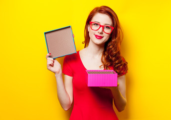 photo of beautiful young woman opening cute gift on the wonderful yellow studio background