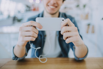 Attractive young man or freelance is sitting in cafe and using his mobile