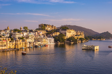 Fototapeta premium The famous city palace on Lake Pichola reflecting sunset light. Udaipur, travel destination and tourist attraction in Rajasthan, India