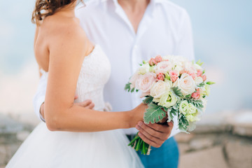Wedding bridal bouquet of Lisianthus and Cineraria silver in the hands of the bride. Wedding in Montenegro.