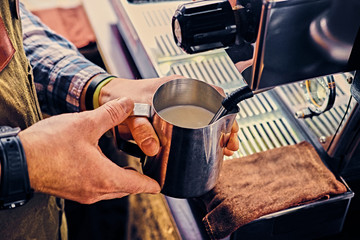 Fototapeta na wymiar A man preparing cappuccino in a coffee shop.