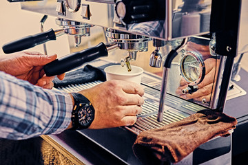 A man preparing cappuccino in a coffee shop.