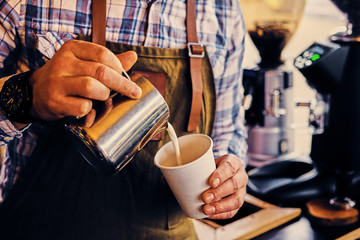 A man preparing cappuccino in a coffee shop.