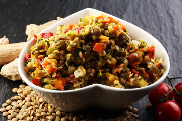 Lentil with carrot and pumpkin ragout in a wooden bowl on a wood