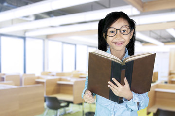 Cute girl holds book in classroom