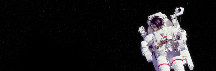 astronaut in an EMU (Extravehicular Mobility Unit) in deep space (banner format 3x1, elements of this image are furnished by NASA)