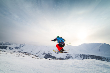 Naklejka na ściany i meble snowboarder snowboarding on fresh white snow with ski slope on Sunny winter day