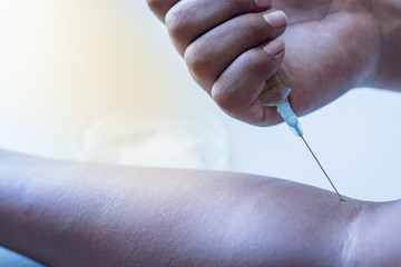 Male drug addict hand, himself an injection.