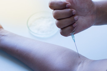 Male drug addict hand, himself an injection.