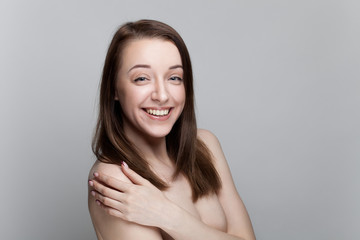 Isolated on gray background studio portrait of young brunette with manicure on nails