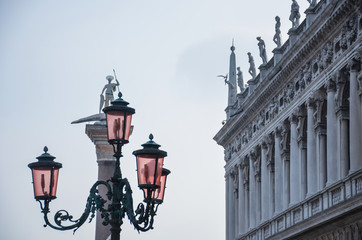 Fototapeta na wymiar Street lamp and a monument against the white sky, Italy