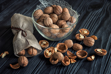 Some walnuts on a black wooden table background.