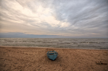 Fototapeta na wymiar Beautiful landscape of Boat on the beach in cloudy weather. Vintage Boat in the seashore. Azerbaijan Caspian Sea Novkhani