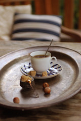 charming vintage still life with Coffee in a porcelain cup, almonds, hazelnuts brown sugar and blueberries  on a bronze dish  
