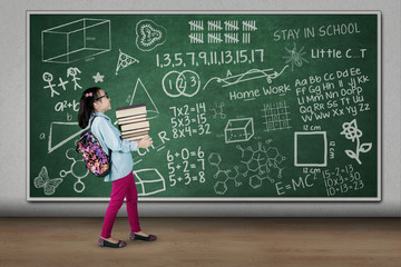 Little girl carrying pile of books