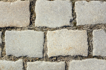 Tiled with paving stone bricks path's fragment as an abstract background