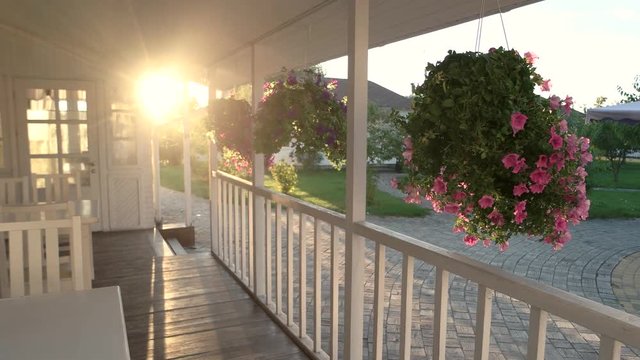 House porch and sunlight. Flowers moving in the wind.