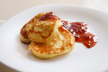 Pancakes doused in strawberry jam on a white plate.Organic, natural, environmentally friendly foods. Made with your own hands.