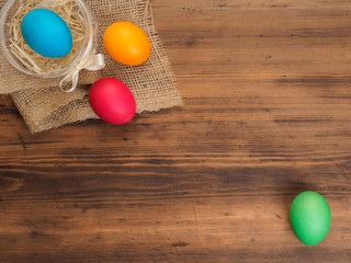 Easter colored egg on burlap and old wooden texture table. Mock up for your greetings card or design. Russian and Ukrainian, orthodox, slavic traditional Easter, rural background
