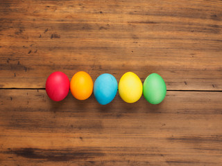 Easter eggs on old brown wood background. Top view, horizontal. Mock up for your greetings card, poster or other design. Russian and Ukrainian, orthodox, slavic traditional Easter, rural background.