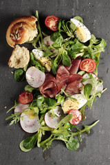 fresh salad with smoked ham, eggs and chia seeds on a trendy modern dark grey services background. Healthy lifestyle concept.