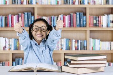 Smiling student shows ok gesture in library