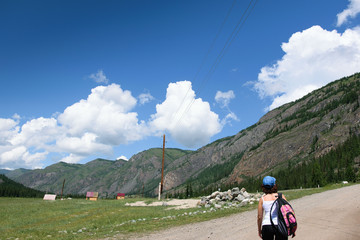 Fototapeta na wymiar Girl with a backpack in the mountains
