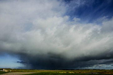 Fototapeta na wymiar Wild weather with big stormy clouds at the Wattensea