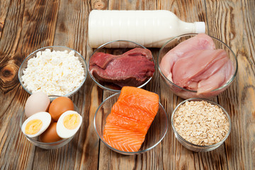 Protein diet, fish, cheese, eggs, meat and chicken wooden background
