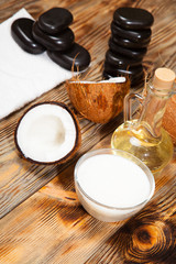 Oil, coconut and stones for a massage on  wooden background