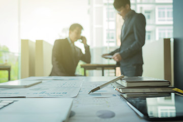 young coworkers crew working with new startup project in modern loft. Pen, laptop, analyze plans on desk