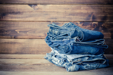pile of jeans on a wooden background