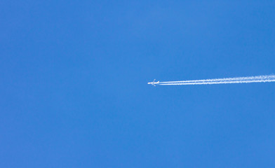 the plane flies in the blue sky. rosy
