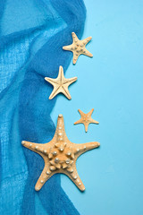 Marine blue background with seashells and starfish in fishing nets with place for your text