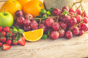 Many types of fruit placed on a wooden floor.