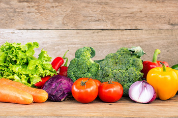 Various types of vegetables on a wooden floor for healthy cooking.