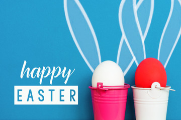 Easter eggs with Rabbit ears in colored buckets on white, selective focus image, Card Happy Easter 