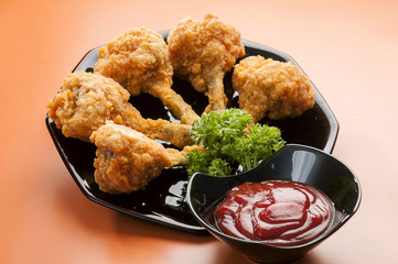 Chicken Lollypop on Black plate with parsley & catchup  