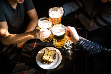 Cheers. Close-up top view of people holding mugs with beer
