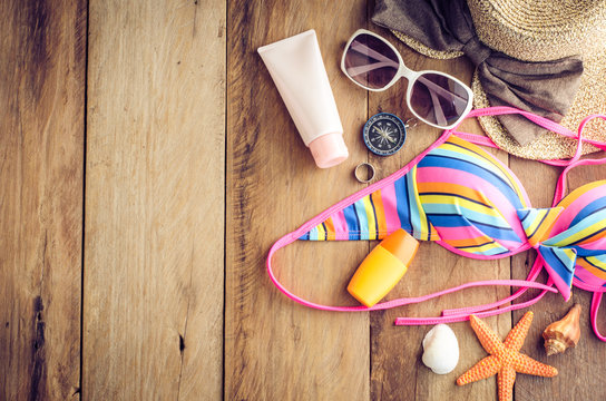 Beauty colorful bikini and accessories on wooden floor for trip on summer