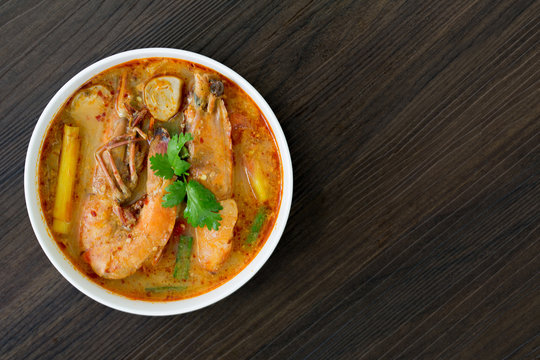 Tom yum kung in white bowl on wooden table, Still life image and Select focus, space for text.Tom yum kung in white bowl on wooden table, Still life image and Select focus, space for text..