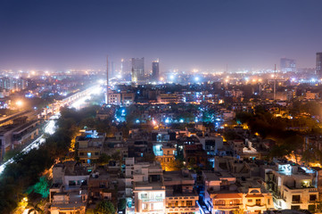 Fototapeta na wymiar Noida cityscape at night with houses, office, skyscrapers, streets and metro rails visible. Lots of construction is visible as well showing the development