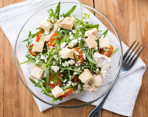arugula salad with boiled chicken and goat cheese in bowlfor healthy meal