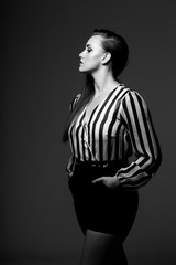 Obraz premium red head model with an edgy personality looking sexy in a dark studio with edgy lighting