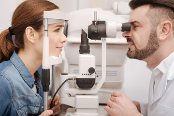 Pleasant delighted woman looking at her doctor