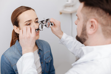 Professional male ophthalmologist preparing to do an eye test