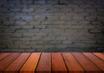 Selected focus empty brown wooden table and wall texture or old black brick wall blur background image. for your photomontage or product display