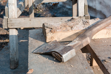 The axe lies on a log. Old axe.
