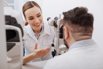 Delighted friendly optometrist interacting with her patient